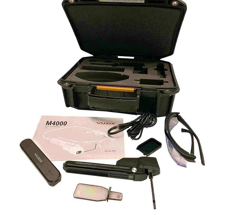 Vuzix M4000 AR headset with accessories laid out: protective case, safety glasses, cables, and instruction manual.